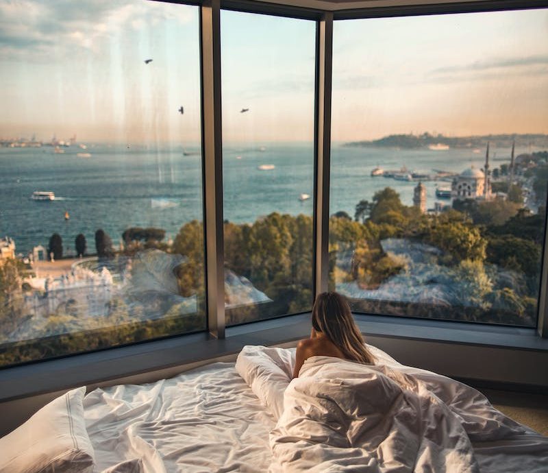 Woman Laying Down on Bed Inside Room