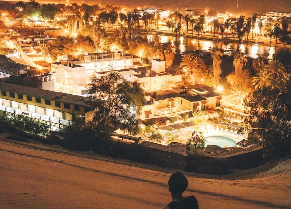 man sitting on sand at night