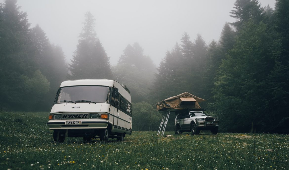 a van and a truck parked in a field