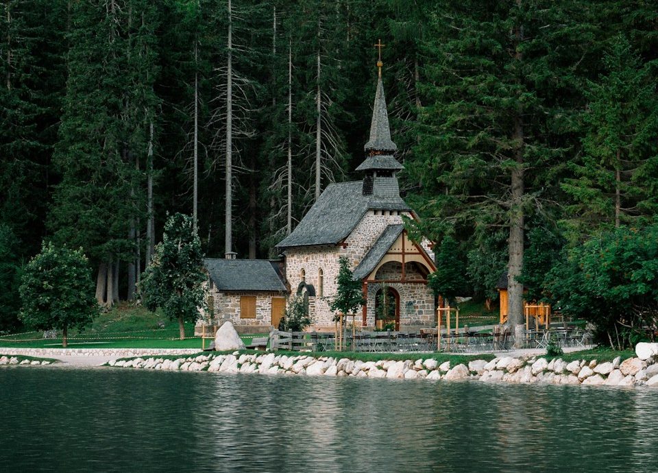 a small church on the shore of a lake