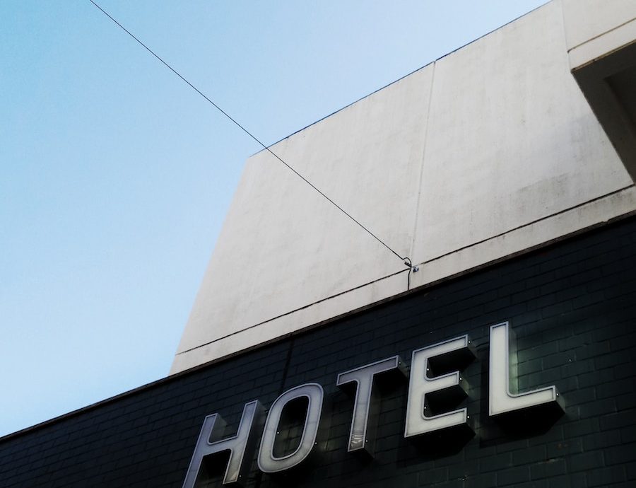 black and white concrete hotel building under a calm blue sky