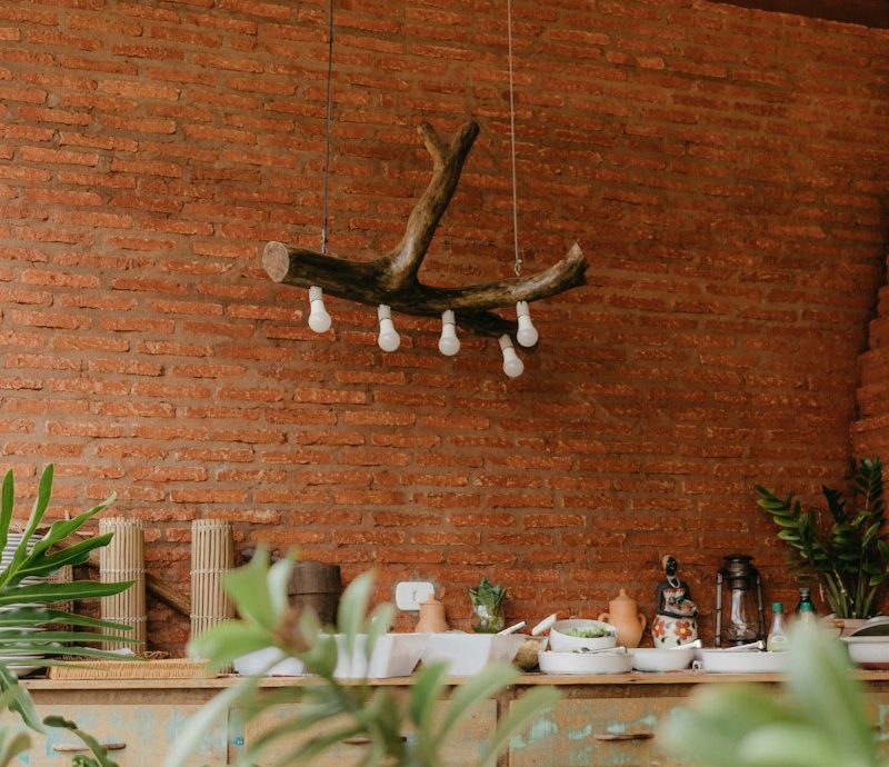 a room with a brick wall and a plant hanging from the ceiling