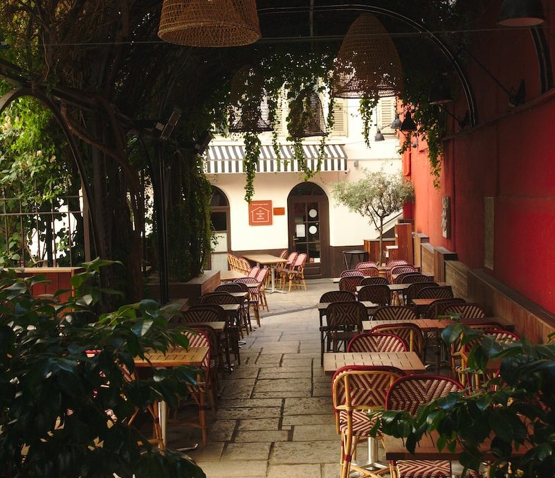 a patio with tables, chairs and plants