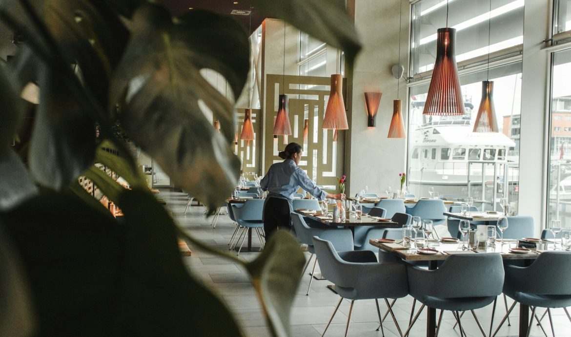 woman in front on brown dining table and chairs inside building