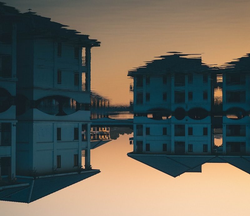 a reflection of a building in a body of water